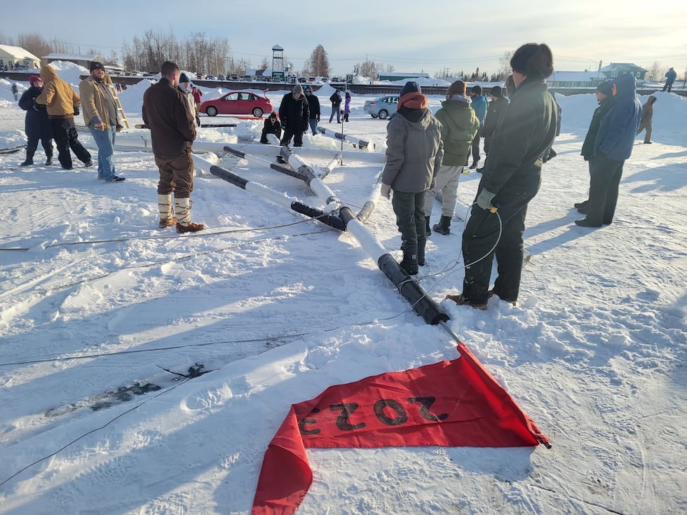 People gather to help put up the famed tripod on the Tanana River during Tripod Days.