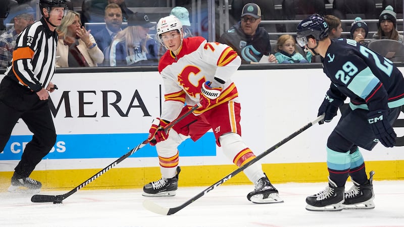 Calgary Flames center Walker Duehr (71) controls the puck with Seattle Kraken defenseman Vince...